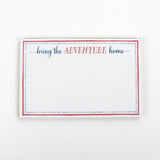 Luxe large notepad with quote ‘Bring the Adventure Home’ in blue and red typography, bordered with dotted design for chic desk stationery. placed in a white background