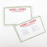 Luxe large notepad with quote ‘More of More is Wonderful’ in red lettering, featuring a dotted border and green trim, perfect for stylish note-taking. placed in a white background