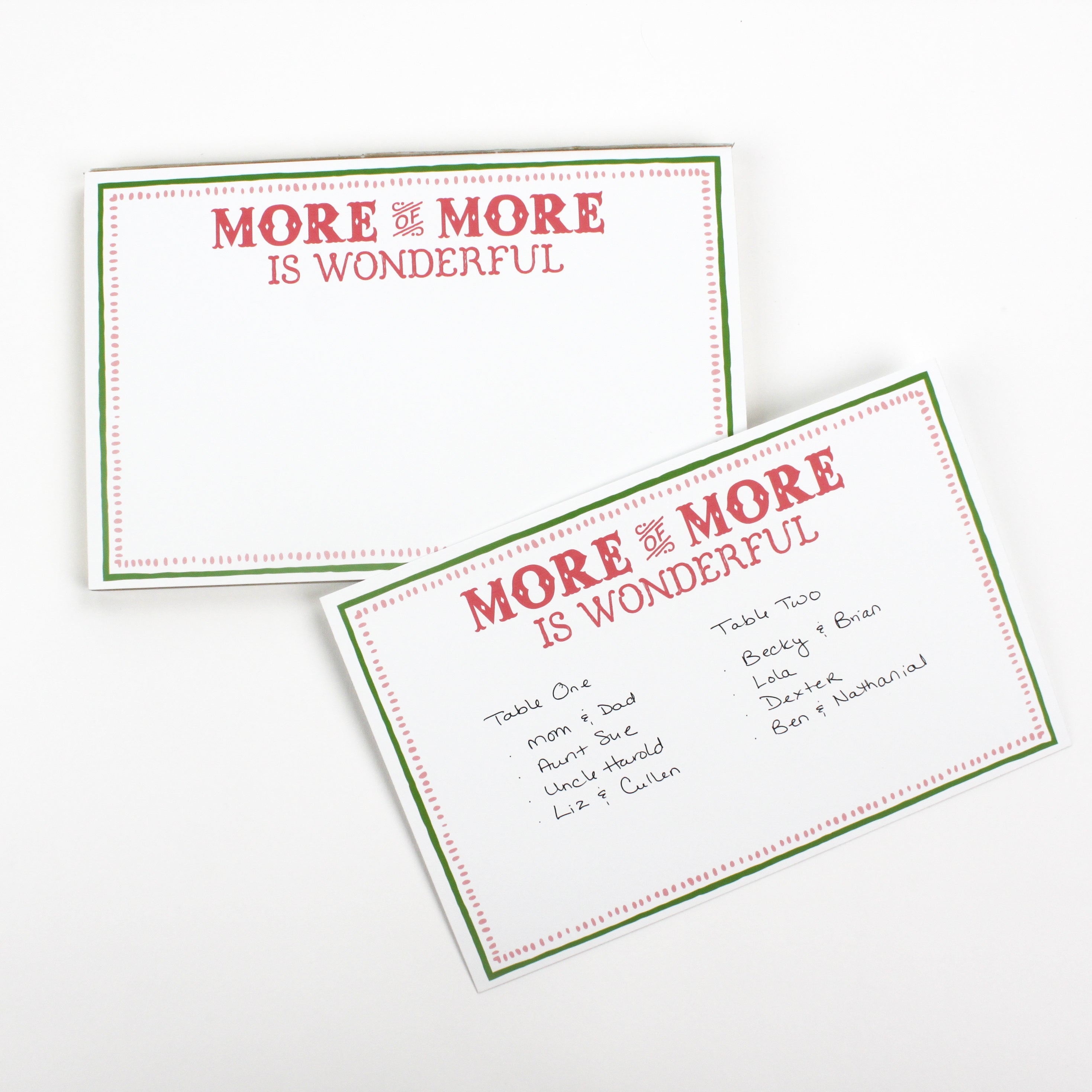 Luxe large notepad with quote ‘More of More is Wonderful’ in red lettering, featuring a dotted border and green trim, perfect for stylish note-taking. placed in a white background