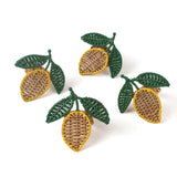 Set of 4, lemon napkin rings in the shape of a lemon with two green leaves against a white background
