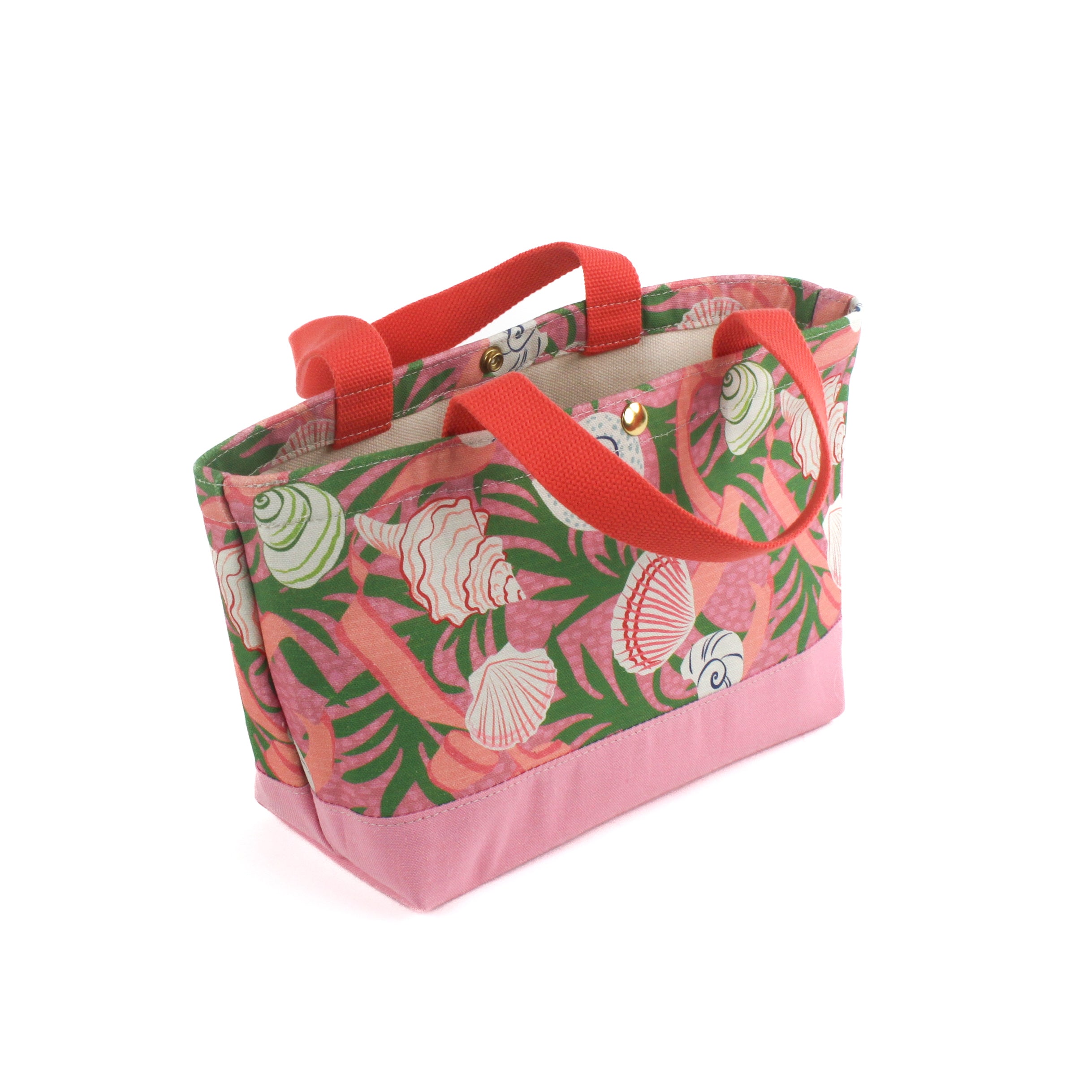 small Shell Seekers canvas tote bags with pink fabric with a repeating seaweed and shell motif.