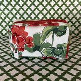 Side view Cottage Grove Geranium is a floral toiletries bag with a red, green, and white color scheme, featuring a geranium design.