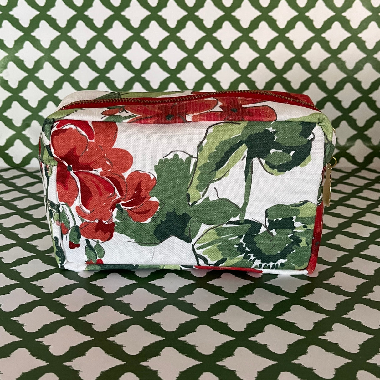 Side view Cottage Grove Geranium is a floral toiletries bag with a red, green, and white color scheme, featuring a geranium design.
