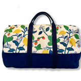A side view of Strawberry Hill canvas duffel bag with a multicolored floral pattern and a zipper.