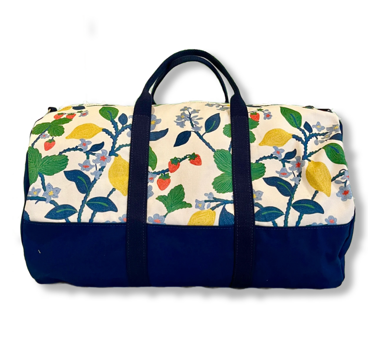 A side view of Strawberry Hill canvas duffel bag with a multicolored floral pattern and a zipper.