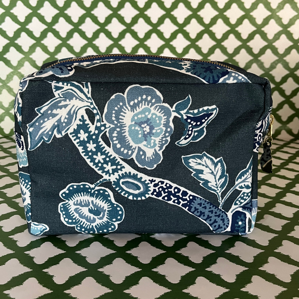 Side view of Temple Garden toiletry bag in navy blue features light blue floral motif.