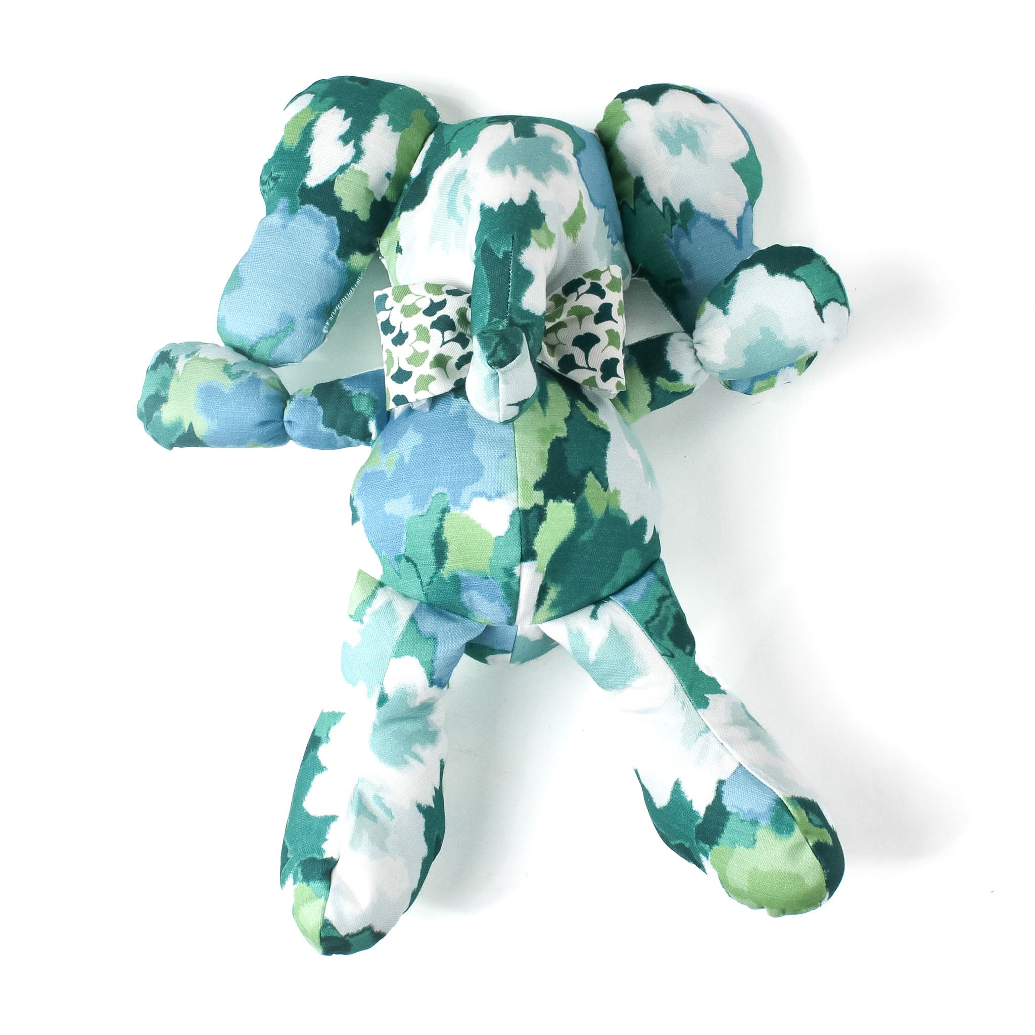 Green and blue patterned stuffed elephant toy with a matching bow.