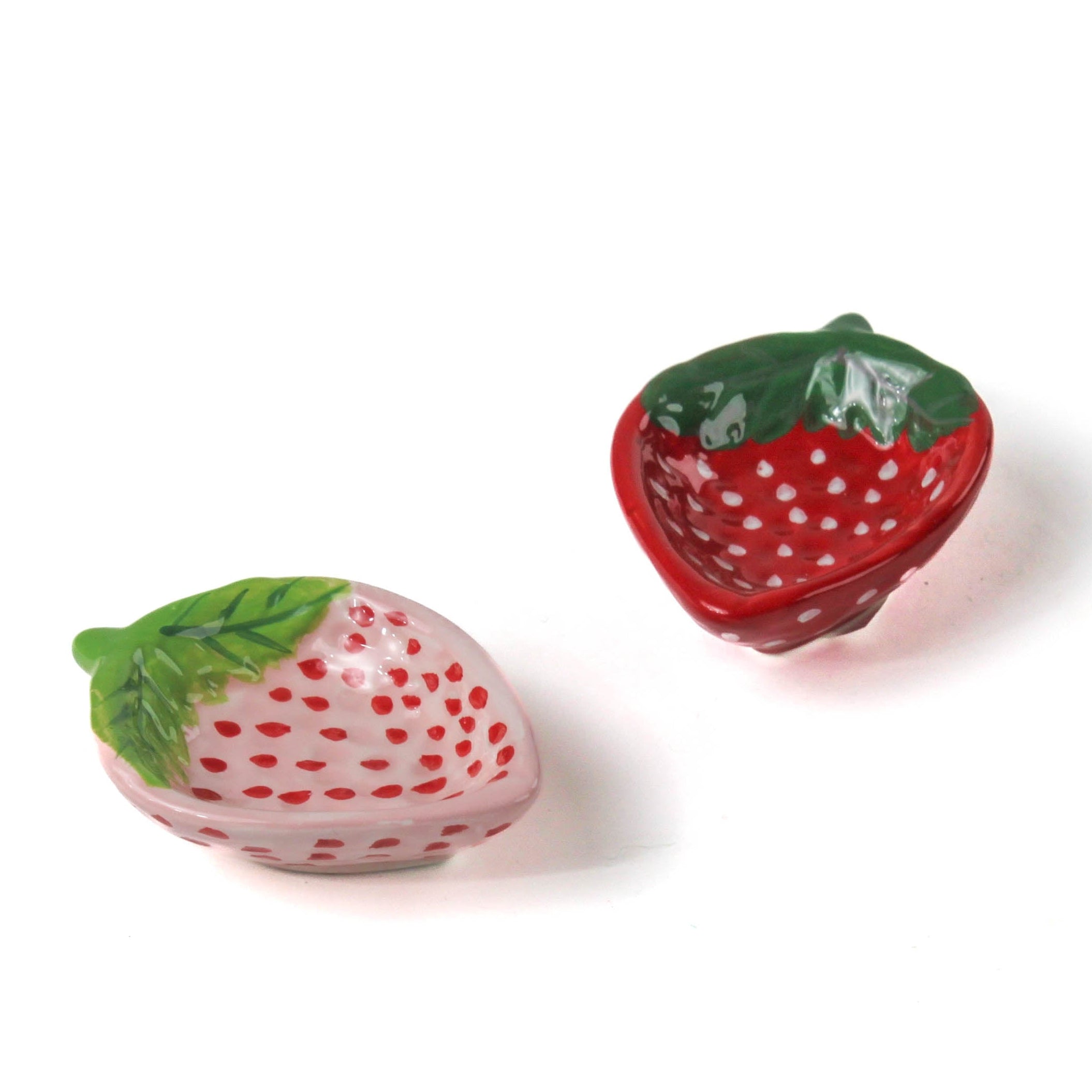 pink and red ceramic strawberry bowls on a white background
