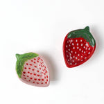 pink and red ceramic strawberry bowls on a white background