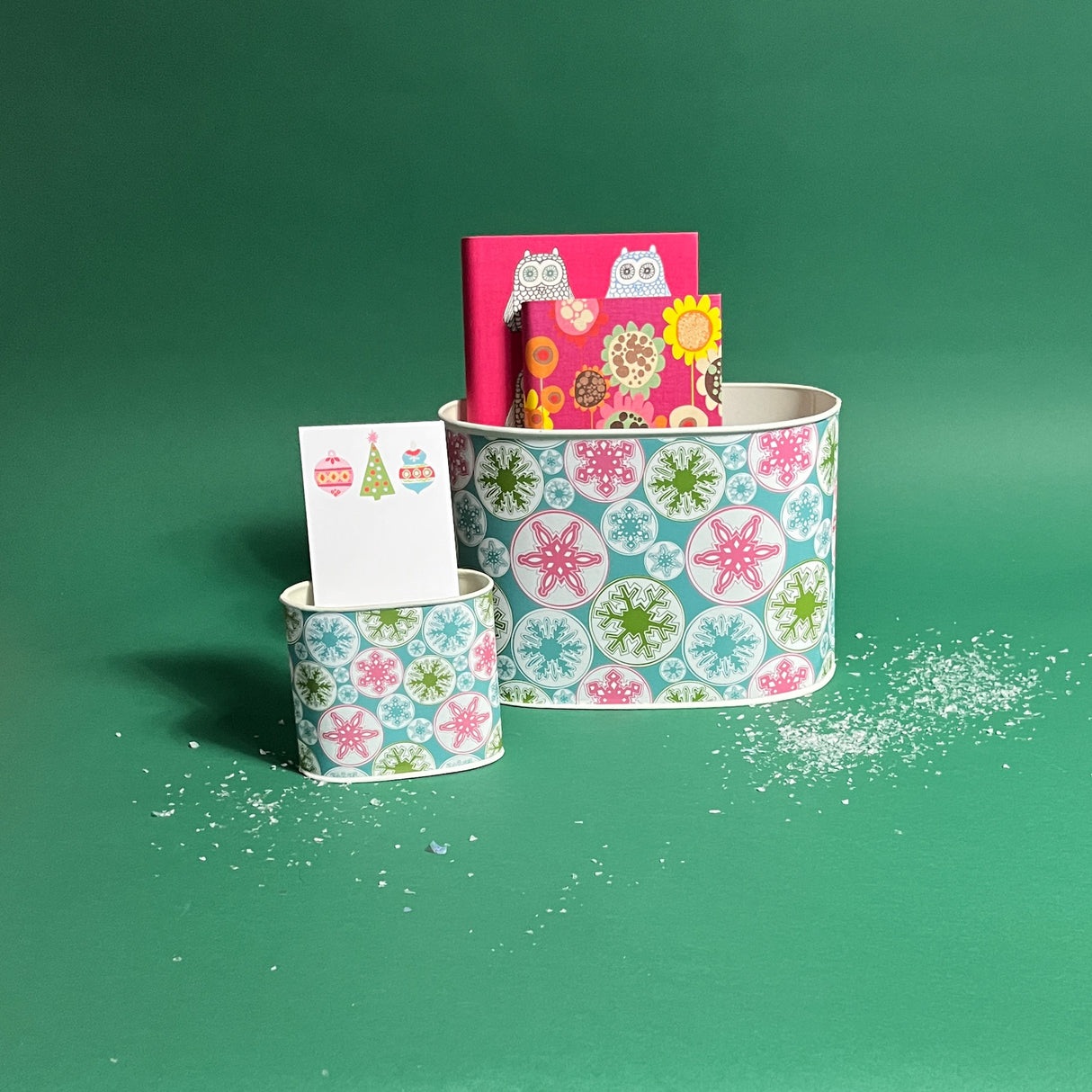 Snowflake Wonderland filled duo of Christmas caddies in large and small on a green background