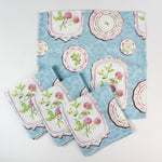 Set of cloth napkins featuring a blue background with vintage floral plate designs.
