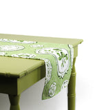 Side view of a green and white patterned table runner draped over a green table.