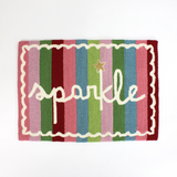 A striped rectantgular Christmas rug that says "sparkle" and has a white scalloped motif at the border
