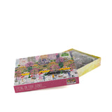 Opened 1000 piece jigsaw puzzle with spring city park scene in decorative box