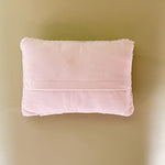 A white easter pillow with three orange carrots back view