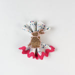 Confetti-print cloth napkin styled with a woven bunny napkin ring and pink scalloped trim.