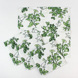 Set of cloth napkins with a green botanical and bunny print laid out together.
