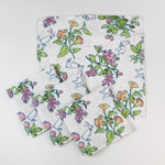Set of cloth napkins featuring a colorful botanical and bunny print on a white background.