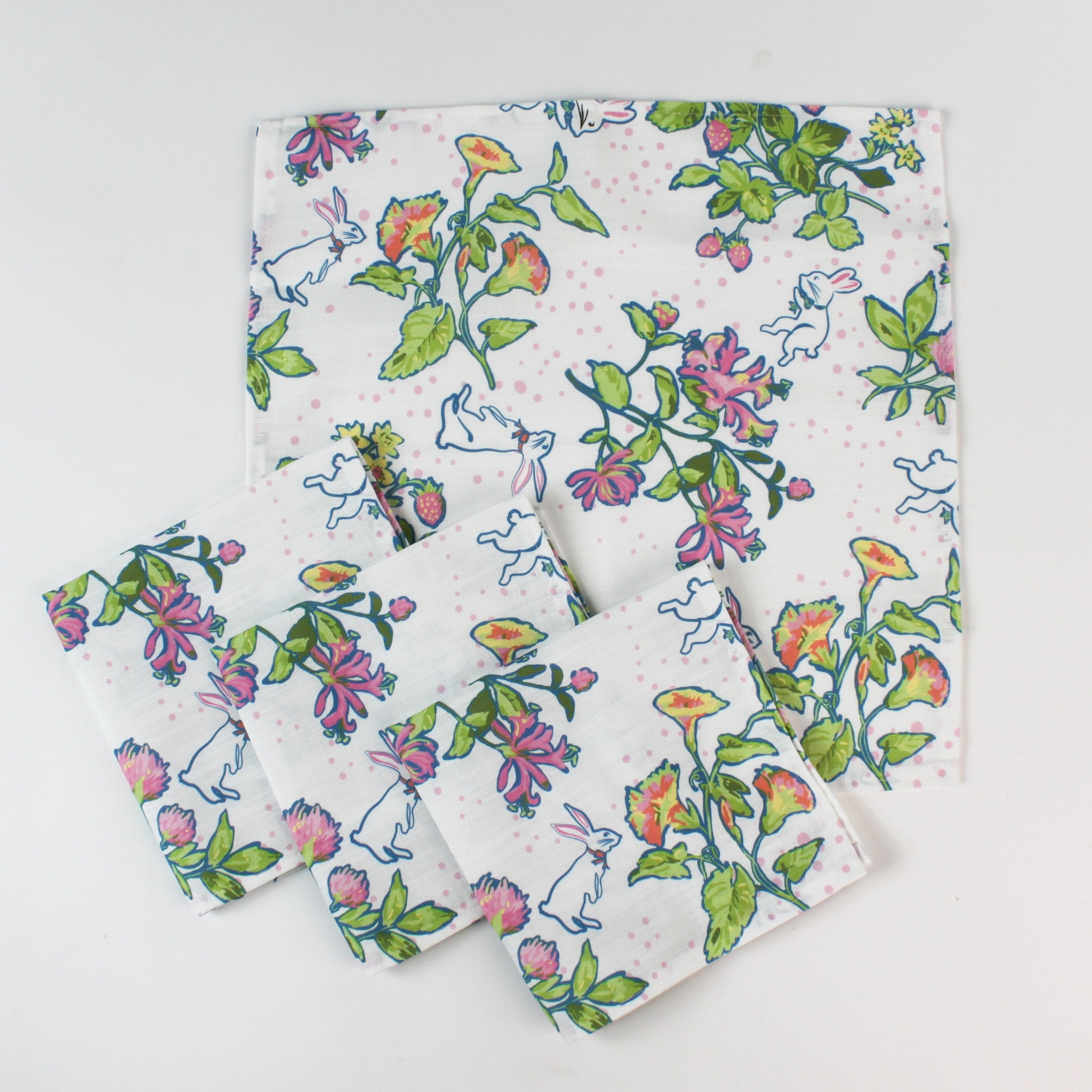 Set of cloth napkins featuring a colorful botanical and bunny print on a white background.