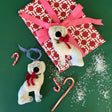Two hand-crafted felt Staffordshire dog christmas ornamentswith red bows and candy cane decorations, set against a patterned background.