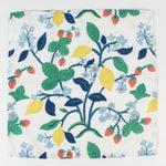 Cloth napkin laid flat with a botanical strawberry, lemon, and floral pattern.