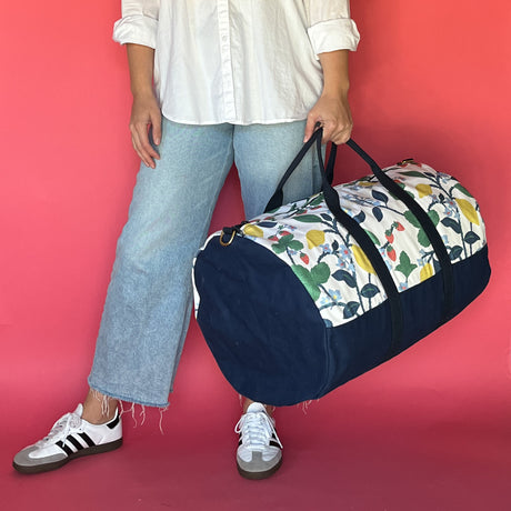 Model carrying the Strawberry Hill duffle bag with an end view