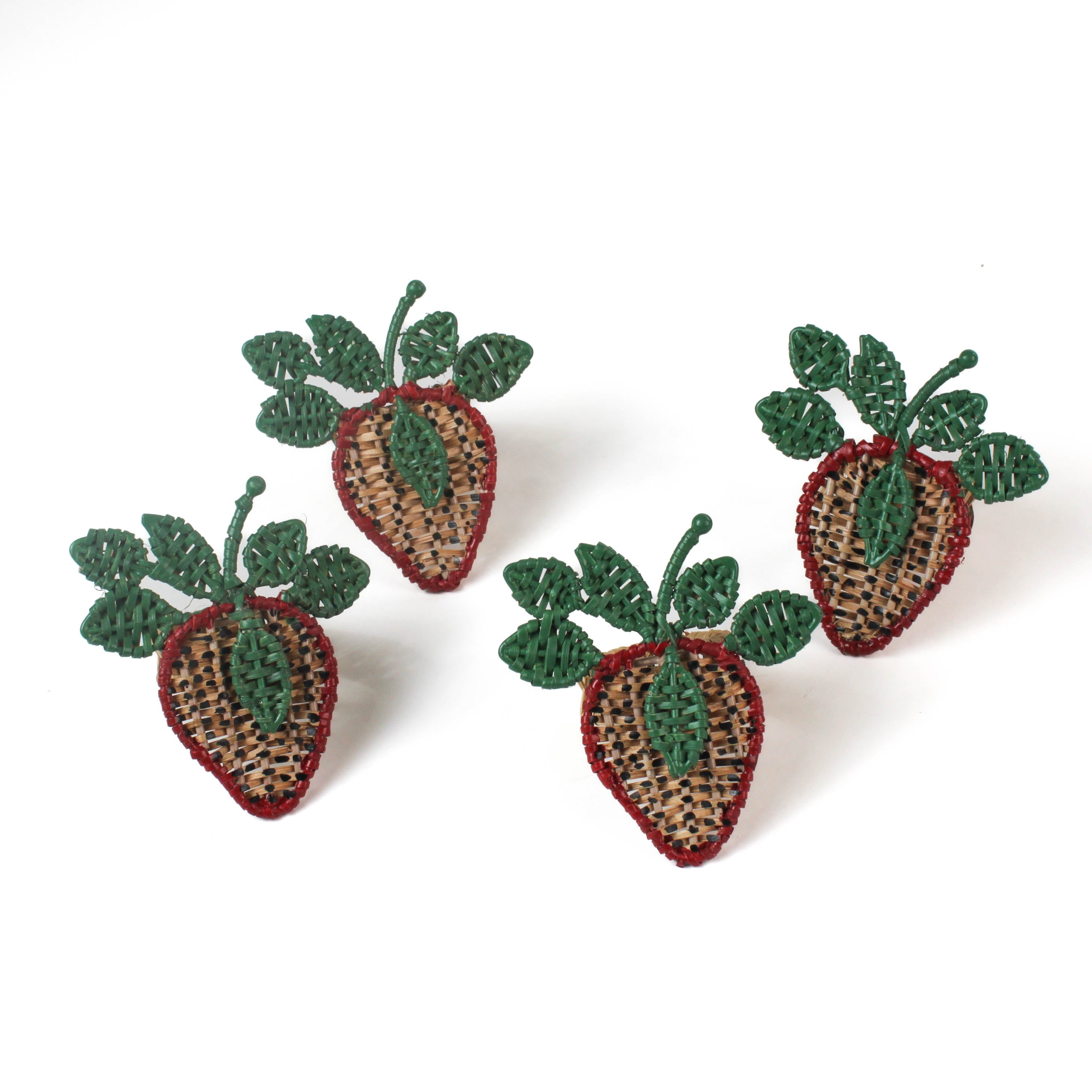four strawbery rattan napkin rings with green leaves and a red outline on a white background. 