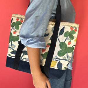 A navy and white tote bag made from lemon and strawberry fabric