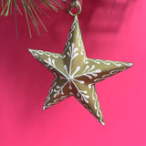 a gold star ornament with white embellishements against a red background