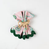 An open,style with gold ring, pink and green chinoiserie cloth dinner napkin in temple garden print in white background.
