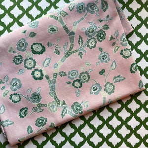 Temple Garden chinoiserie cloth tablecloth on a green and white motif background.