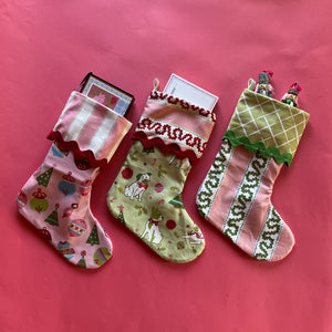 Green, red and pink Christmas stockings in a variety of festive prints. 