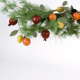 Handcrafted tole metal garland featuring lifelike fruit accents including pomegranate, orange, and lemon with green leaves