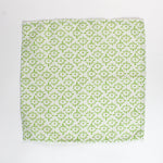 Cloth napkin laid flat with a repeating green floral pattern on light green fabric.