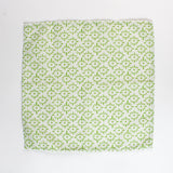 Cloth napkin laid flat with a repeating green floral pattern on light green fabric.