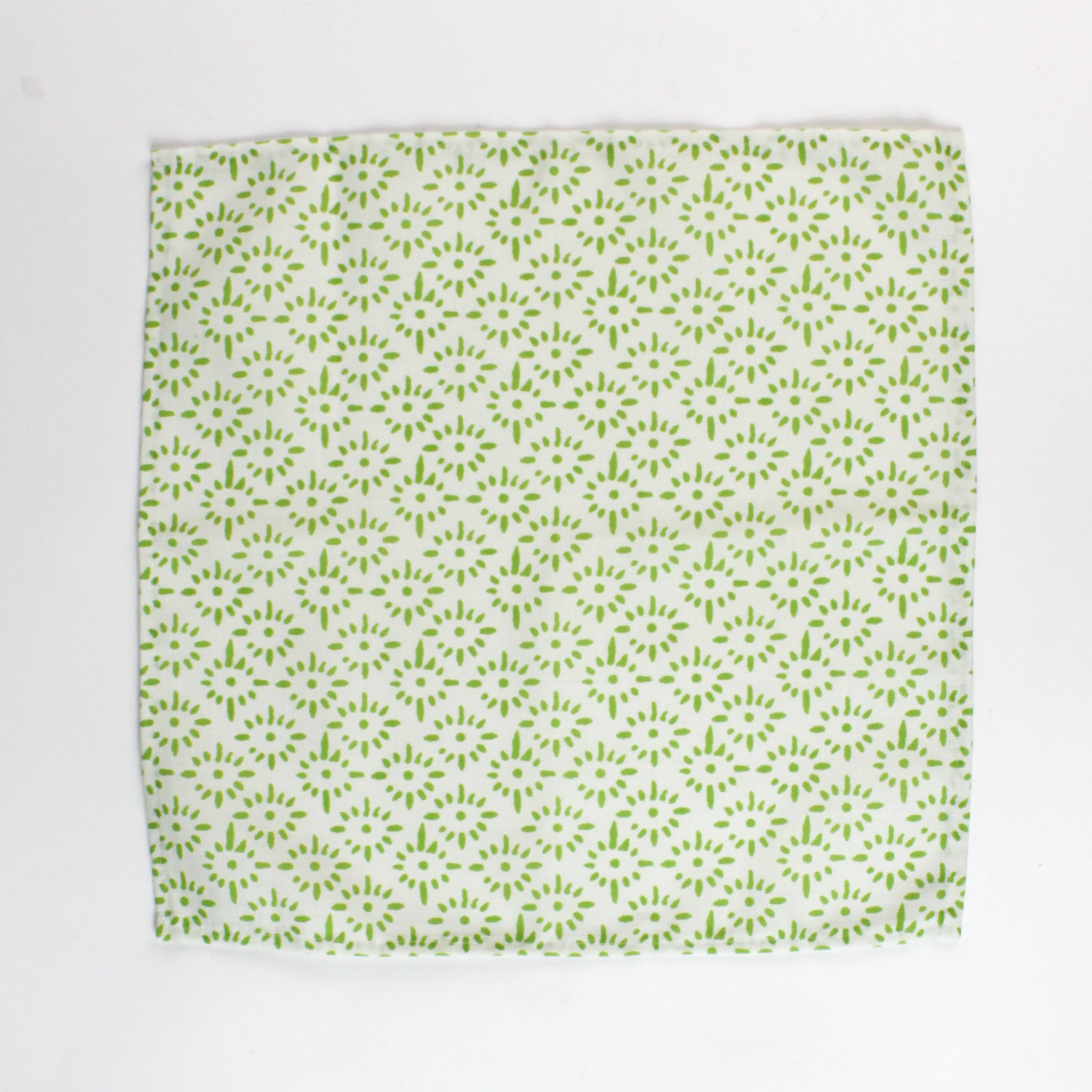 Cloth napkin laid flat with a repeating green floral pattern on light green fabric.