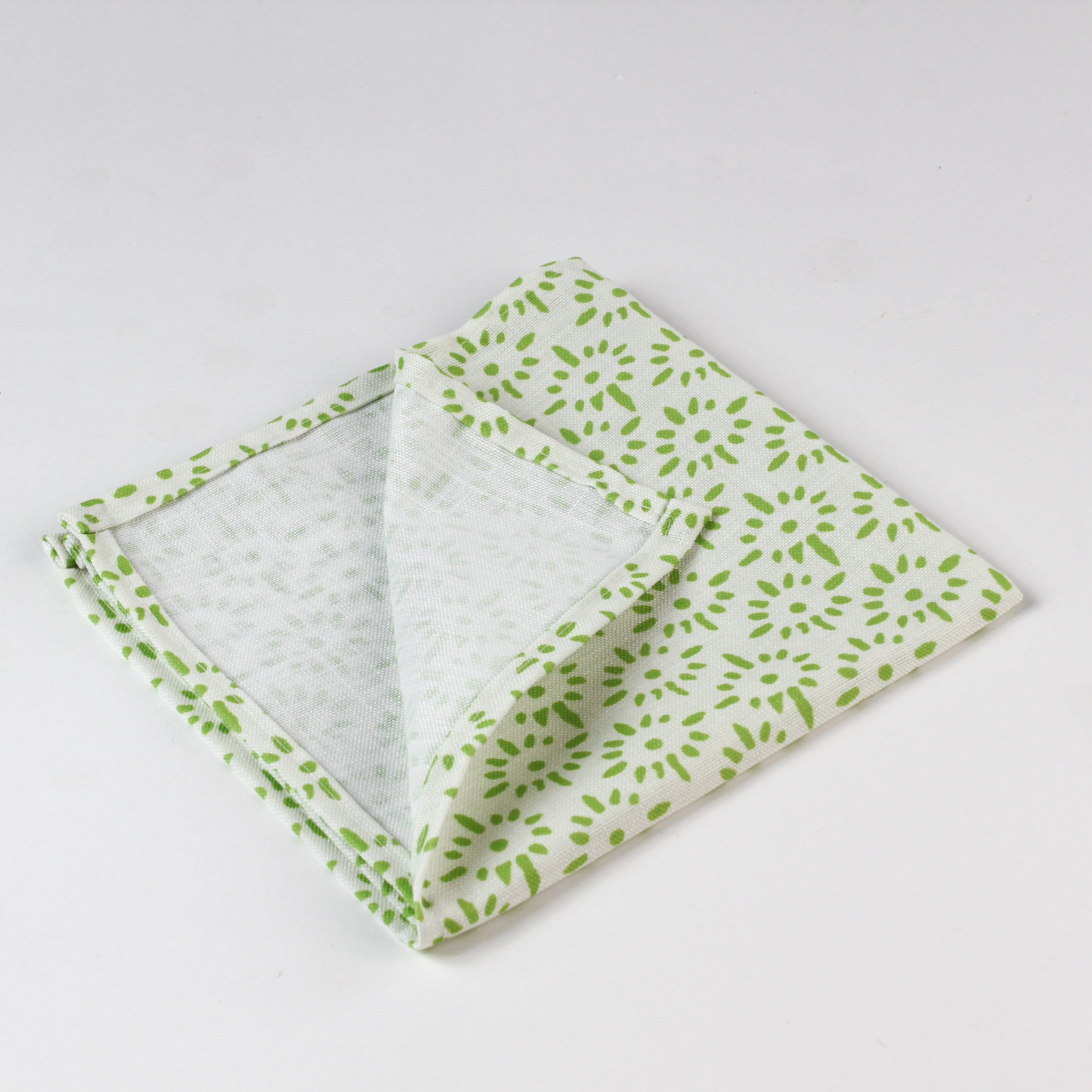 Close-up of folded cloth napkin showing light green fabric with a small floral pattern.