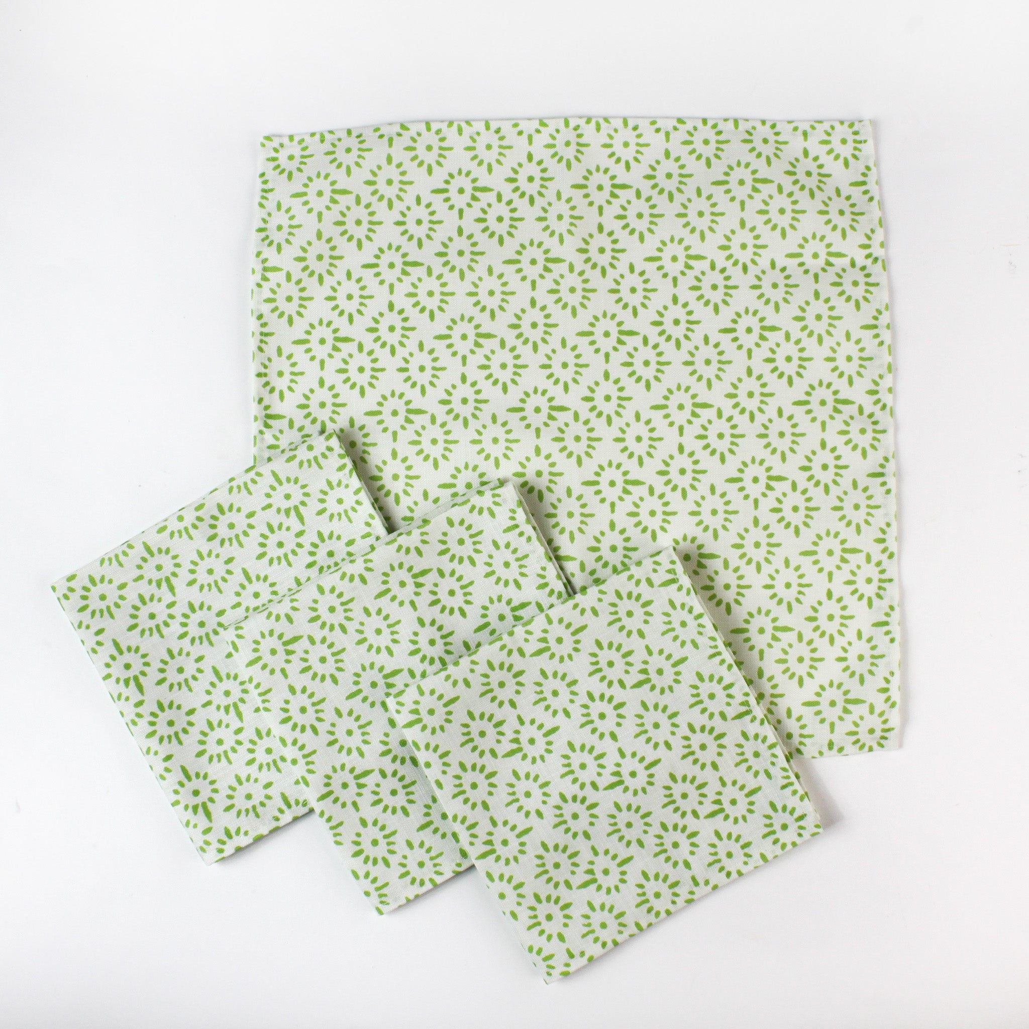 Set of cloth napkins with a light green floral pattern arranged together.
