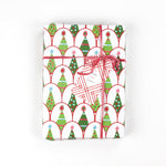 Gift wrapped in Twinkle Trees Christmas paper with pink ribbon and holiday tree gift tag, shown from above.