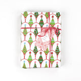 Gift wrapped in Twinkle Trees Christmas paper with pink ribbon and holiday tree gift tag, shown from above.