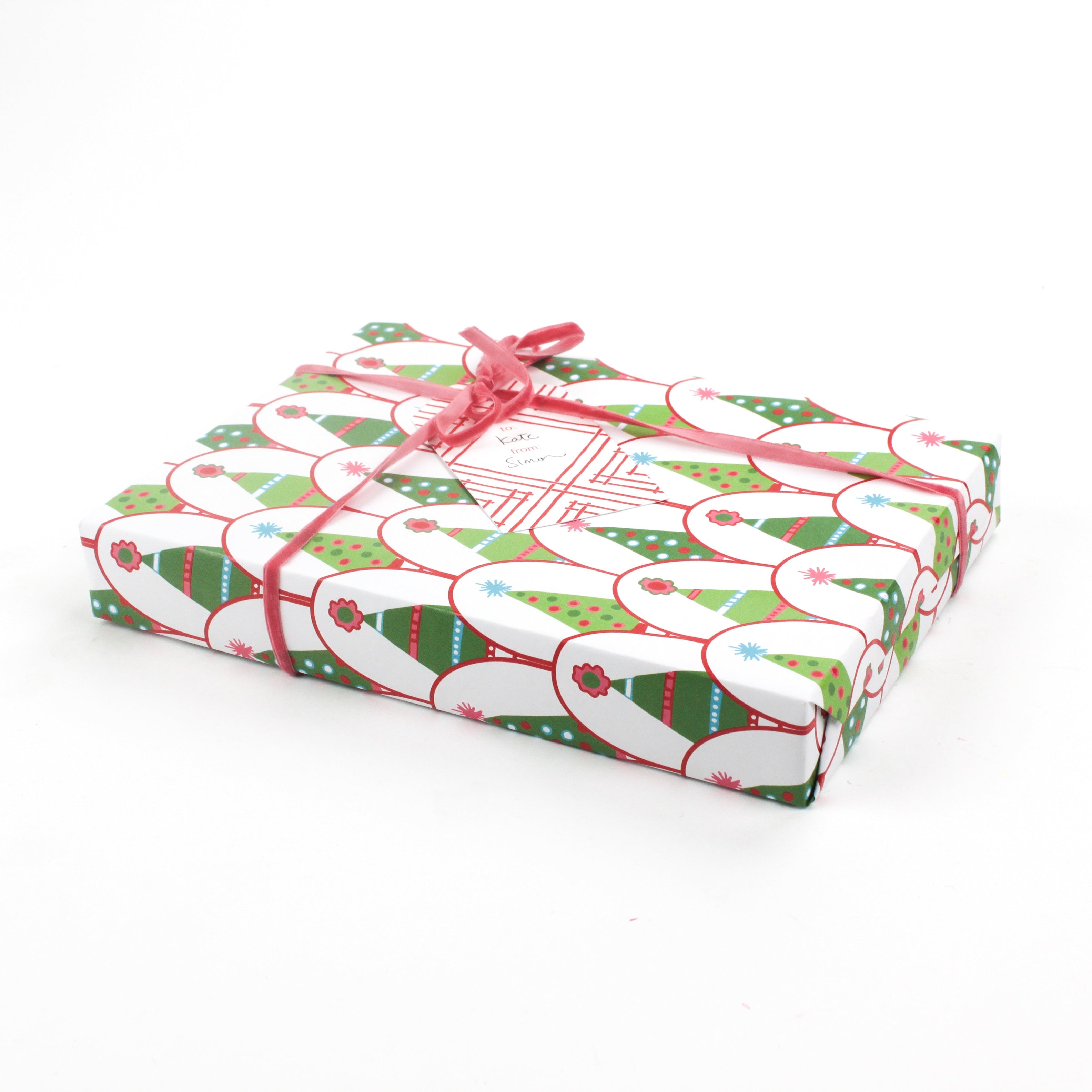 Gift wrapped in Twinkle Trees Christmas wrapping paper with pink ribbon and matching gift tag.