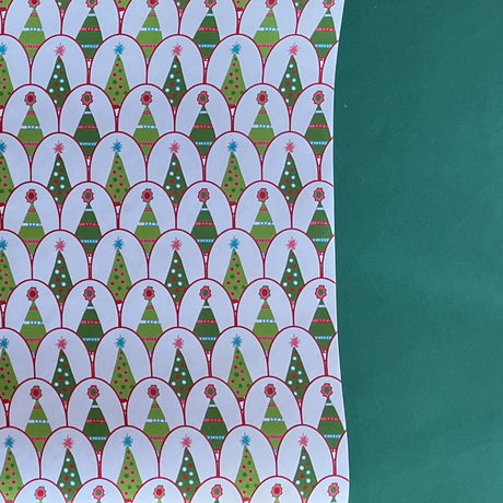 white and green wrapping paper printed with decorated christmas tree motifs