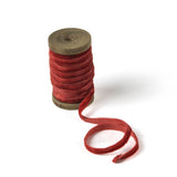 a coral Velvet Ribbon on Wood Spool in a white background