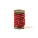 a coral Velvet Ribbon on Wood Spool in a white background