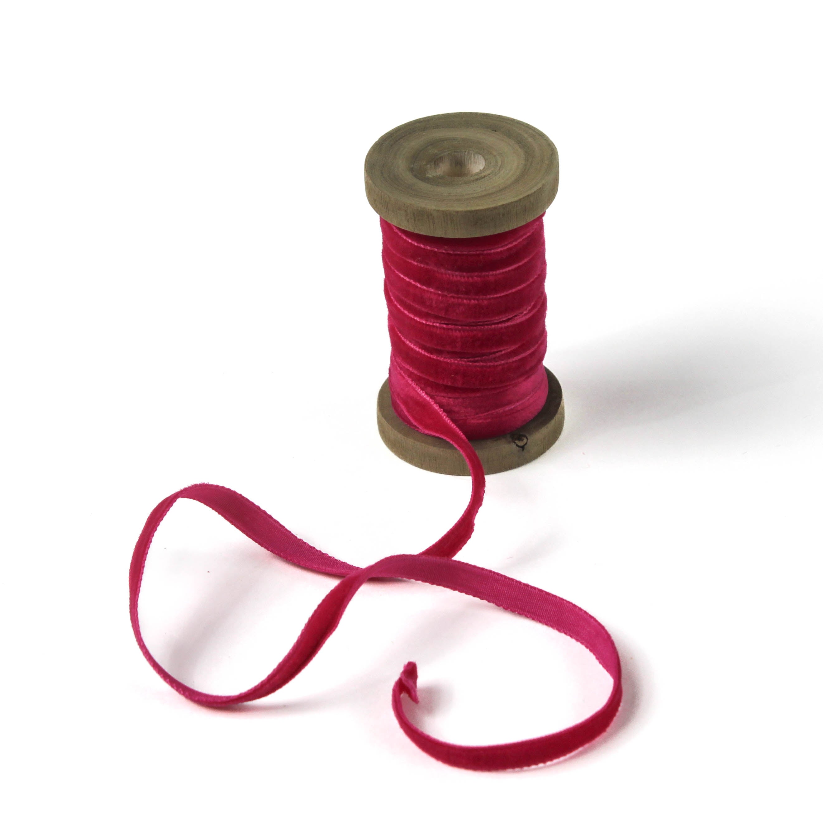 a red Velvet Ribbon on Wood Spool in a white background