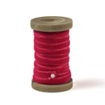 a red Velvet Ribbon on Wood Spool in a white background