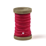 a red Velvet Ribbon on Wood Spool in a white background