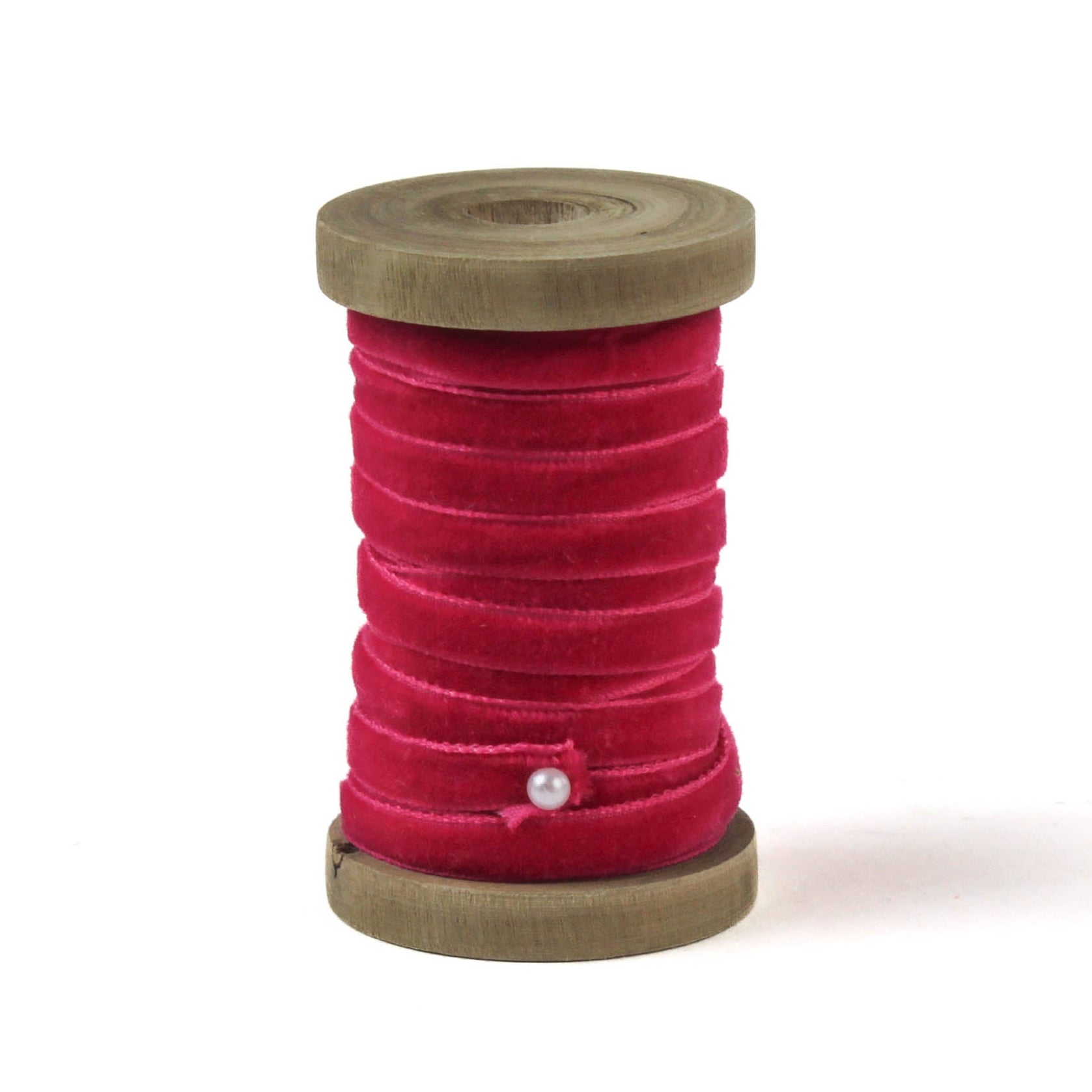 a red Velvet Ribbon on Wood Spool in a white background