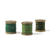 set of 3 green Velvet Ribbon on Wood Spool in a white background
