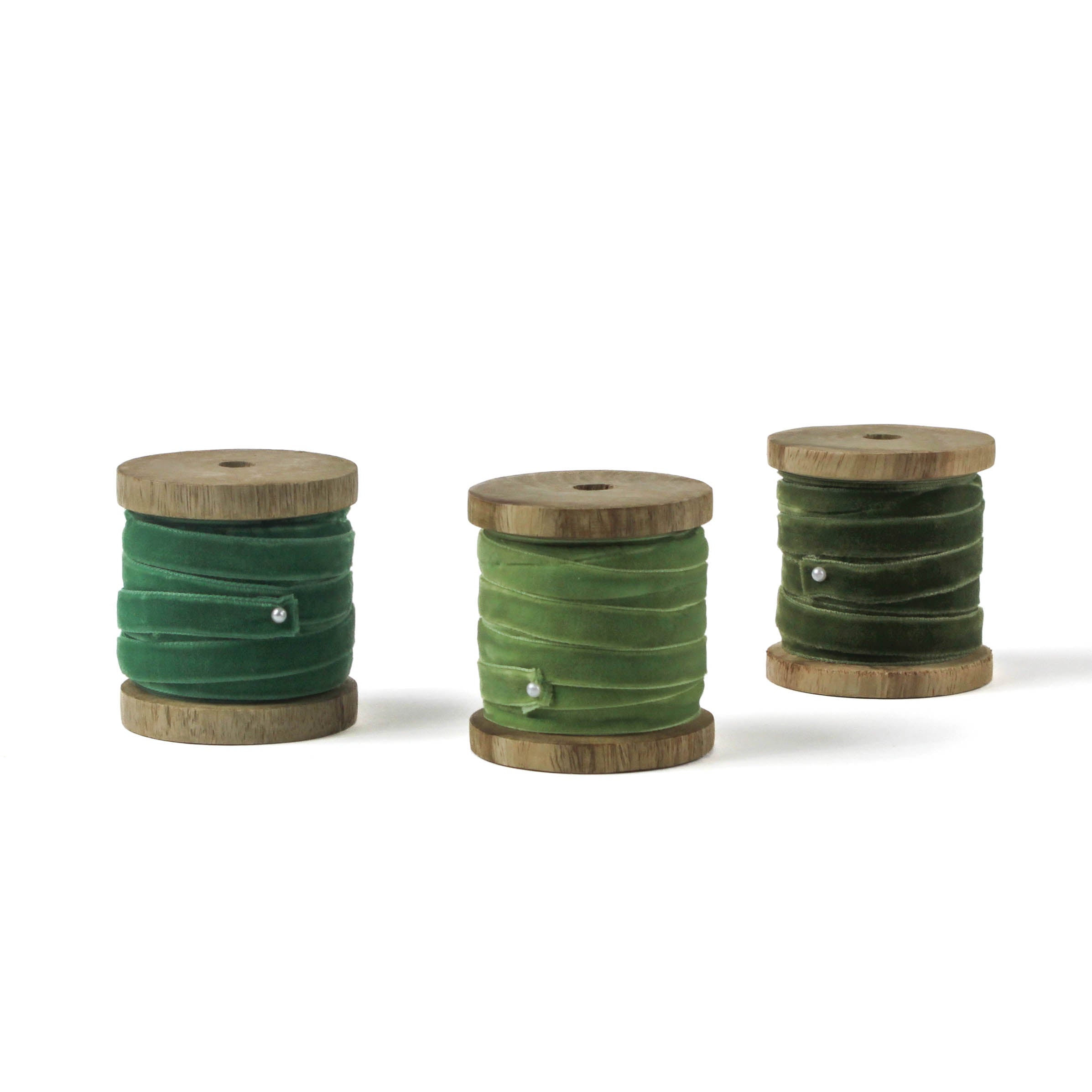 set of 3 green Velvet Ribbon on Wood Spool in a white background